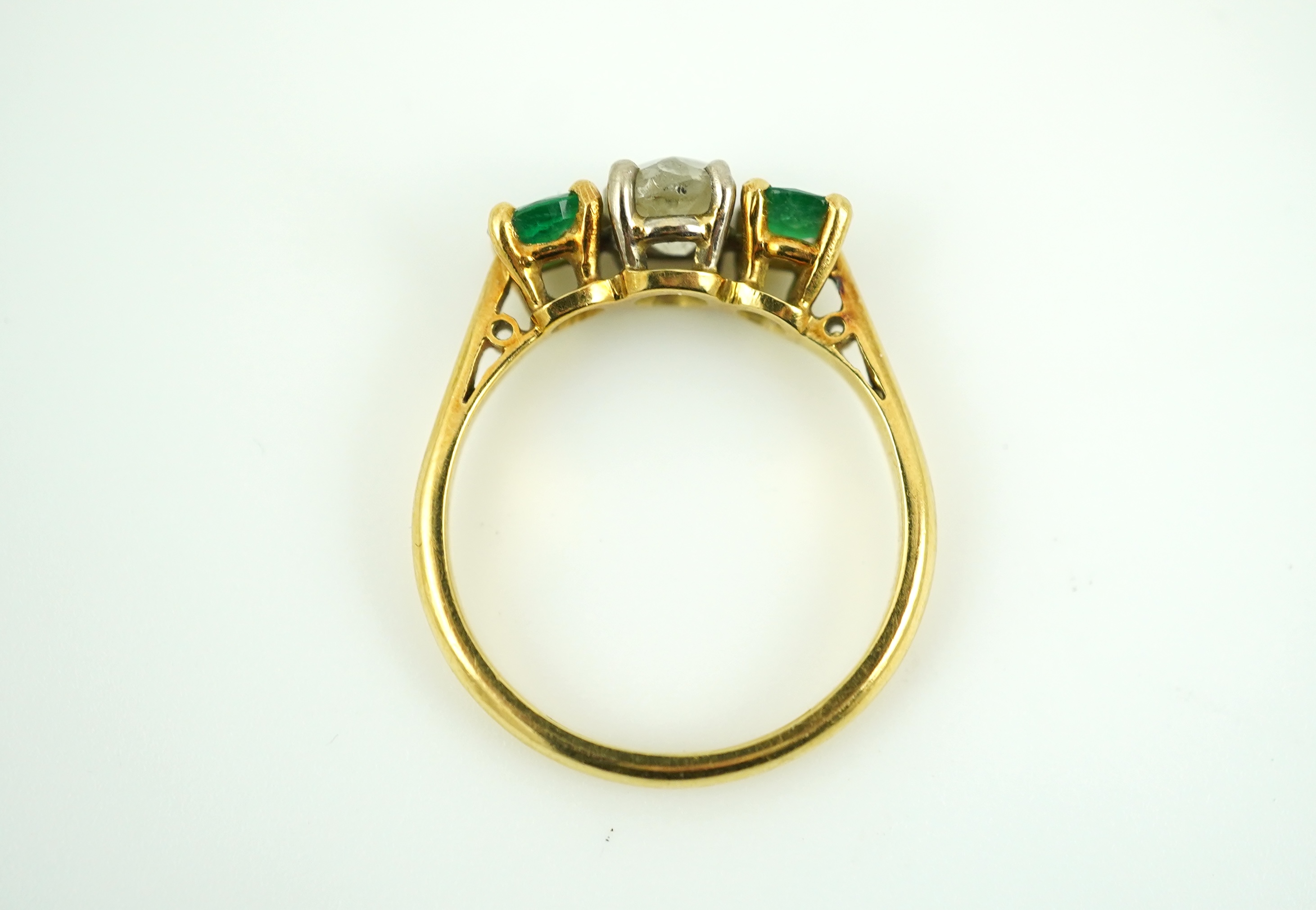 An emerald and diamond three-stone ring